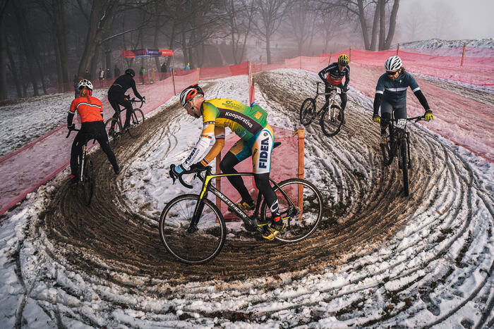 Riders take a snowy spiral carved into the mud