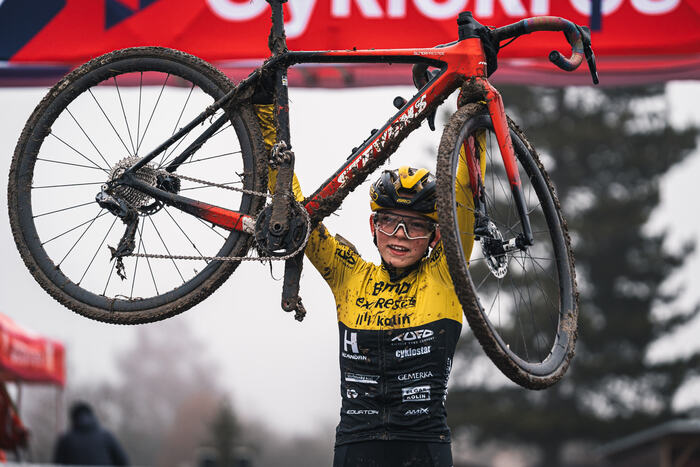 Joy at the finish — bike raised overhead